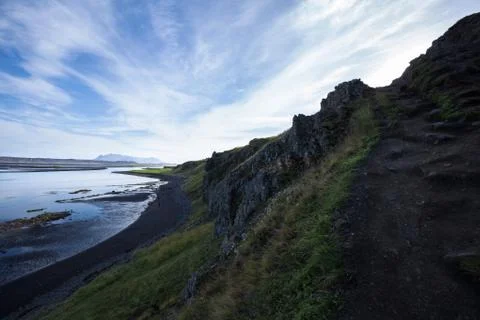 Landscape with cliff and mountain range at the ocean. Light reflections in .. Stock-Fotos
