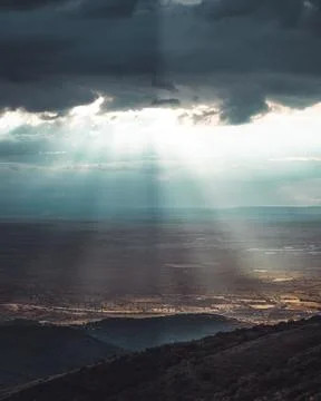 A landscape with clouds opening to sun rays Stock Photos