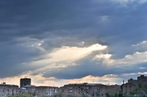 Landscape with a cloudy sky and old residential buildings Stock Photos