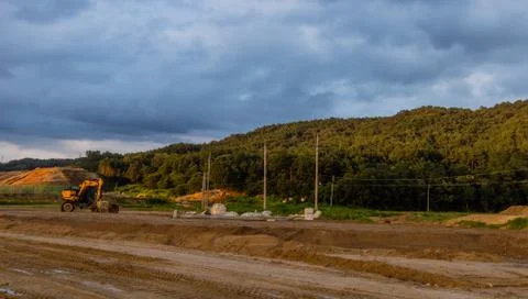 Landscape of a construction site under a dark cloudy sky. Stock Photos