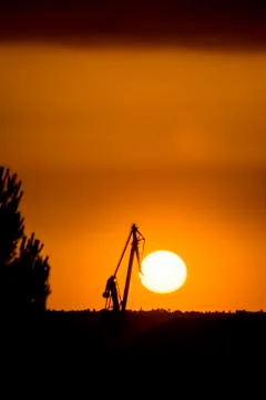 Landscape of a cranes in a harbor at sunset with clouds Stock Photos
