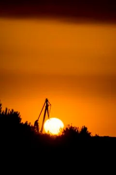 Landscape of a cranes in a harbor at sunset with clouds Stock Photos
