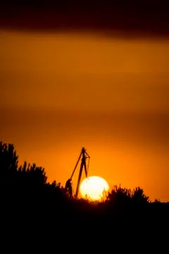 Landscape of a cranes in a harbor at sunset with clouds Foto stock
