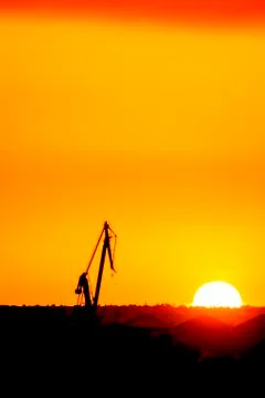 Landscape of a cranes in a harbor at sunset with clouds Foto stock