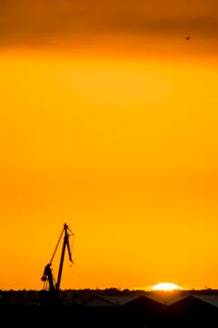 Landscape of a cranes in a harbor at sunset with clouds Foto stock