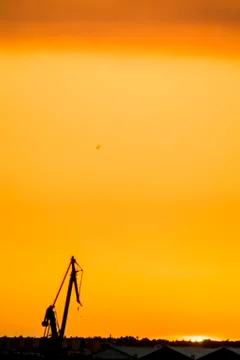 Landscape of a cranes in a harbor at sunset with clouds Stock Photos
