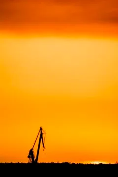Landscape of a cranes in a harbor at sunset with clouds Stock Photos