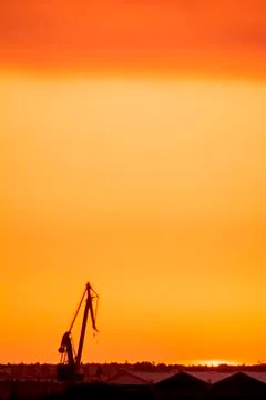Landscape of a cranes in a harbor at sunset with clouds Stock Photos