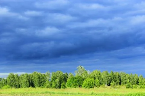 Landscape with dark rainy clouds under the forest Stock Photos