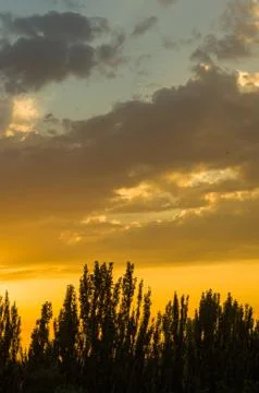 Landscape with dramatic light - beautiful golden sunset with saturated sky an Stock Photos