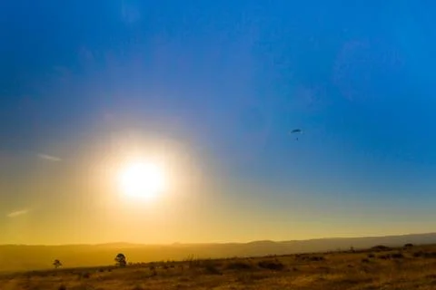 Landscape of the eclipse in the mountains and paragliding in the sky Stock Photos
