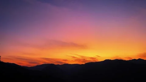 Landscape Epic Orange Sunset Glow over Silhouetted Mountain Range Video stock 332527931
