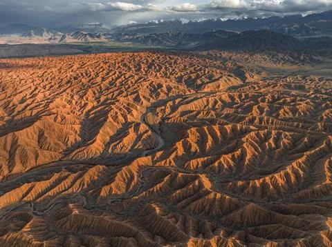 Landscape of eroded hills, badlands at sunset, mountain peaks of the Tian Shan 스톡 사진