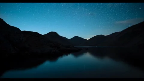 Landscape featuring a tranquil lake surrounded by silhouetted mountains. Stock Footage 297490243