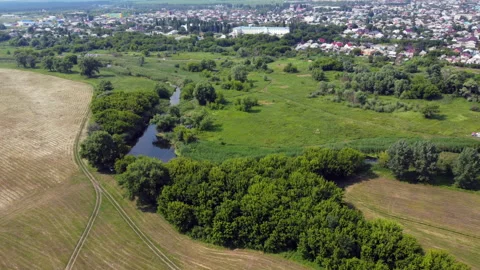 Landscape with fields, a river, and a small town in the distance Stock Footage 234390819