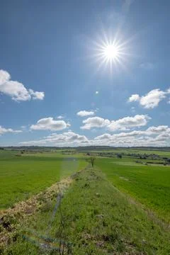 Landscape of green fields with blue sky and clouds Stock Photos