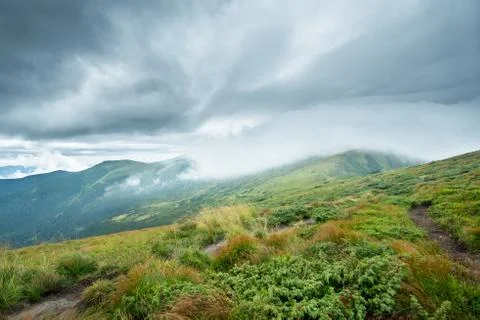 Landscape with green mountains in the clouds Stock Photos