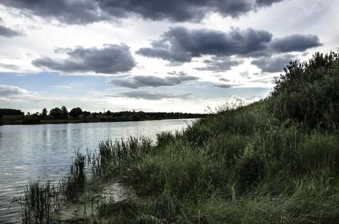 Landscape with the image of the river and clouds in the sky Stock Photos
