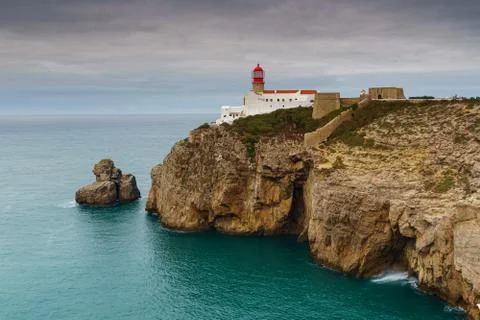 Landscape of the lighthouse and cliffs at Cape St. Vincent at sunset. Algarve Stock Photos