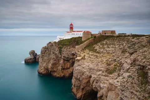 Landscape of the lighthouse and cliffs at Cape St. Vincent at sunset. Algarve Stock Photos