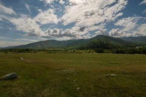 Landscape, Low mountains with a plain in the foreground in cloudy weather Stock Photos