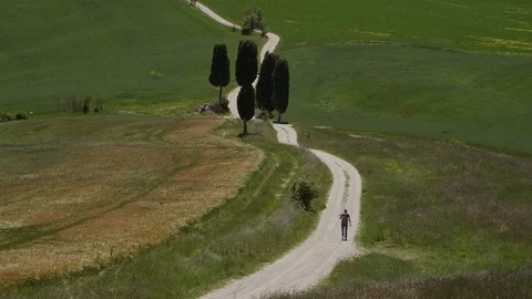 Landscape with man on Gladiator road and cypress trees in Tuscany, Italy, spring 스톡 동영상 124173270