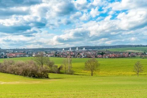 A landscape with meadows and fields in the background are three skyscrapers. Stock Photos