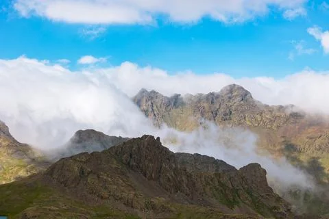 Landscape of the mountain range and rolling clouds over the peaks Stock Photos