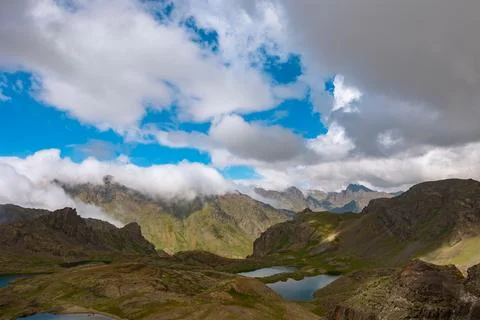 Landscape of the mountain ranges with rolling clouds and lake Stock Photos