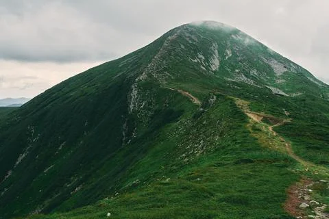 A landscape of a mountainous area covered with grass and stones. Mountains co Stock Photos