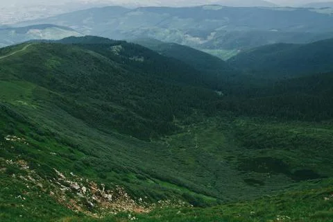 A landscape of a mountainous area covered with grass and stones. Mountains co Stock Photos