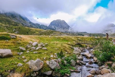 Landscape with mountains and a stream in the foreground. Stock Photos