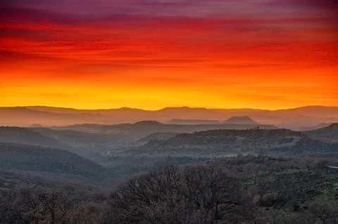 Landscape of mountains at sunset with dramatic red and orange sky Stock Photos