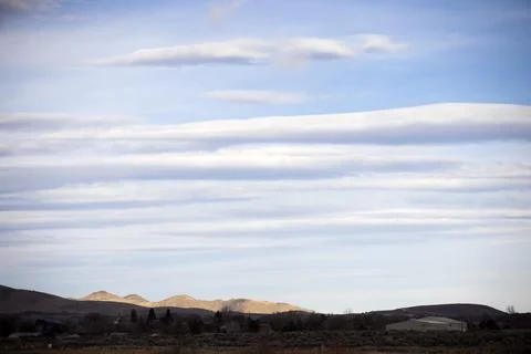 Landscape orientation three quarters of a sky filled with lenticular clouds o Stock Photos