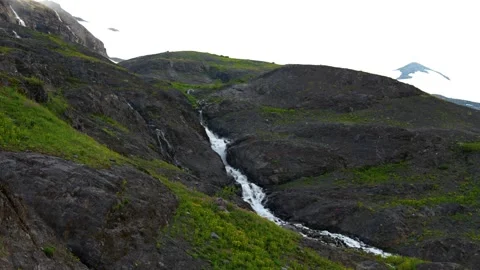 Landscape pan of glacial melt forming a mountain stream high up in the cascade Видео 344990253