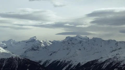 Landscape panorama of clouds passing over snow covered Swiss mountains Stock Footage 129099258