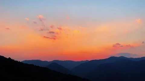Landscape Peaceful Sunset Clouds over Mountain Valley with Orange Hues 動画素材 332527936