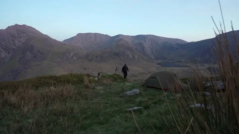 A landscape photographer setting up a camera tripod Vidéo 196749271