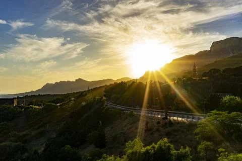 Landscape with the rays of the sun over the road Stock Photos