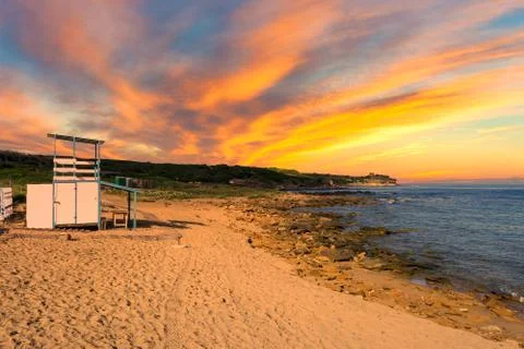 Landscape with rescue tower on the beach at dramatic sunset Stock Photos