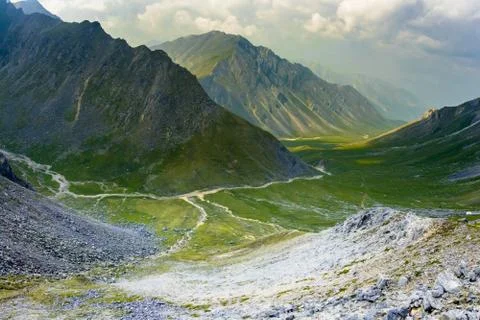 Landscape river flows in a mountain valley in the summer in the clouds Stock Photos