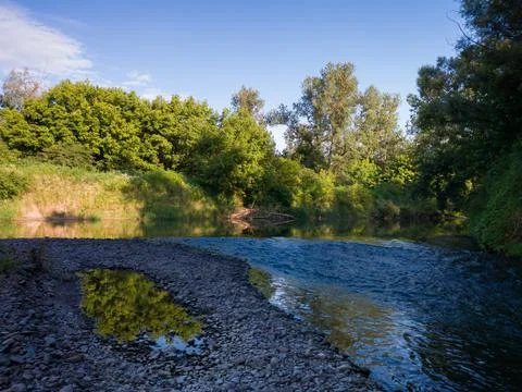 Landscape with river with rapids and flat surface with reflection Stock Photos