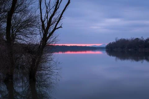 Landscape of river, reflection of distant mountain in calm water and silhouet Stock Photos