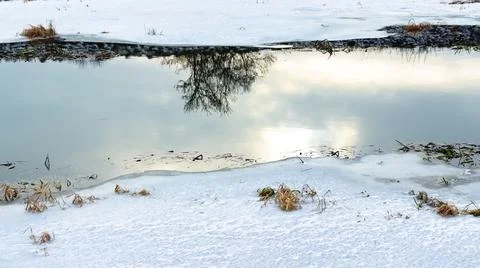 Landscape with a river, trees, reflections in the water in winter. Stock Photos