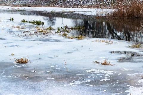 Landscape with a river, trees, reflections in the water in winter. Stock Photos