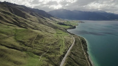 Landscape of a road between mountains and a lake at Lake Hawea, New Zealand. Stock Footage 240515558