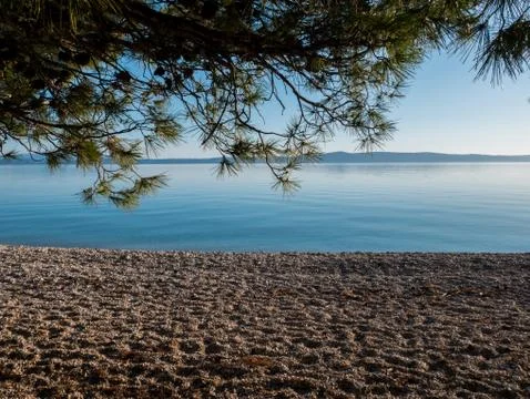 Landscape scene of empty beach and calm blue sea Stock Photos