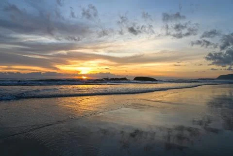 Landscape with seashore and dramatic sky during summer sunset as wallpaper Stock Photos