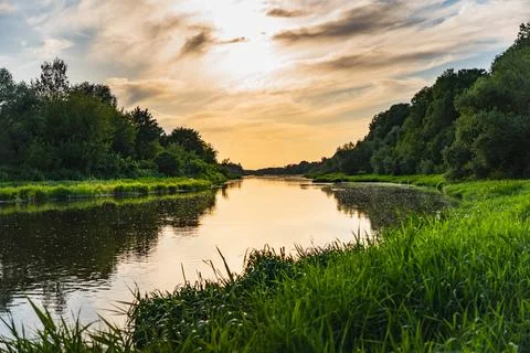 A landscape with the setting sun over the Bug River in summer Photos