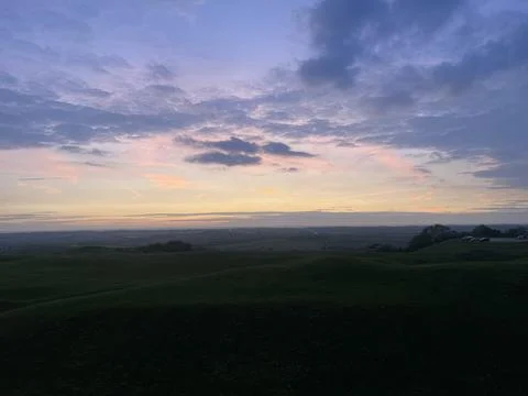 Landscape shot of dramatic sunset sky over hills and valleys Stock Photos